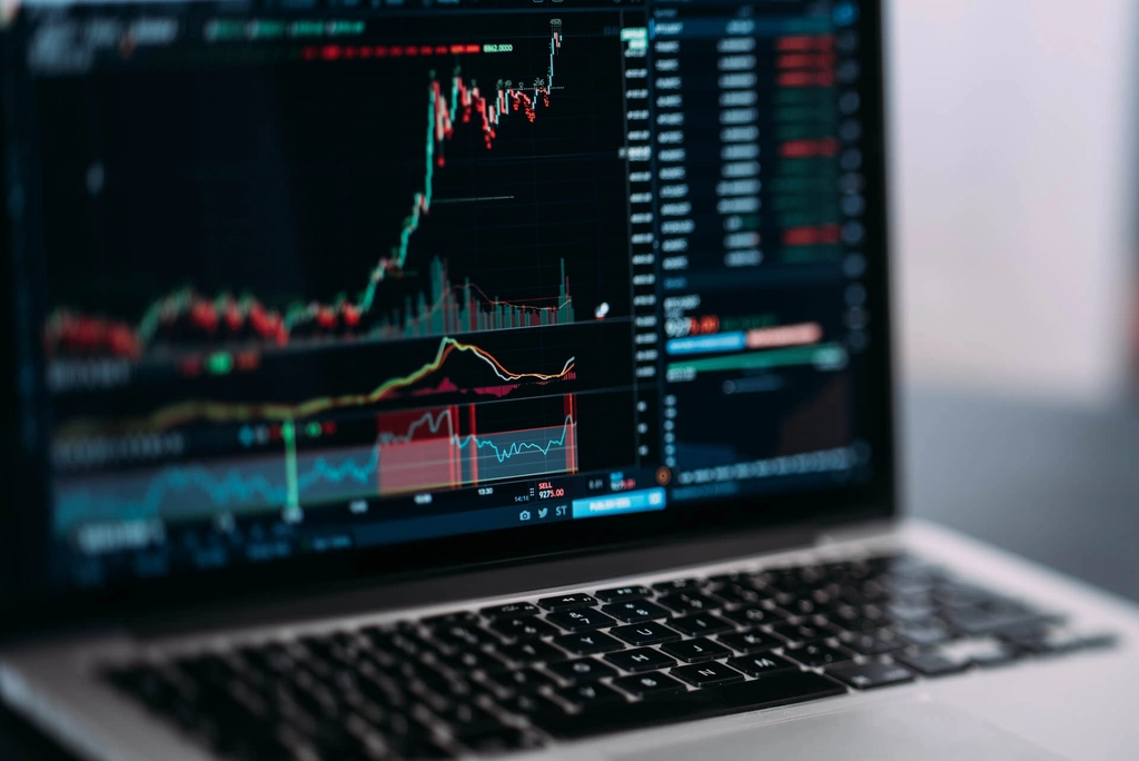 Laptop displaying cryptocurrency trading charts on a desk while evaluating options